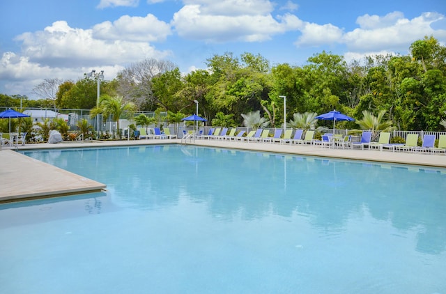 pool with a patio area and fence