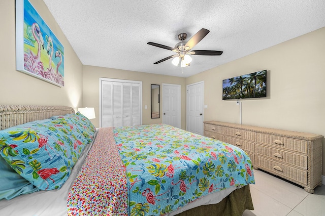 bedroom with a closet, a ceiling fan, a textured ceiling, and light tile patterned flooring