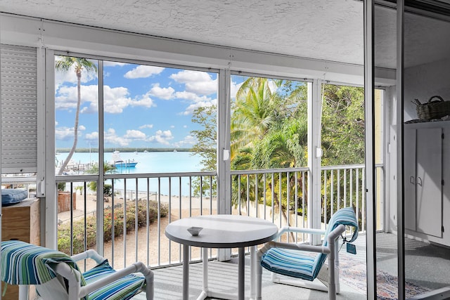 sunroom featuring a water view and a healthy amount of sunlight