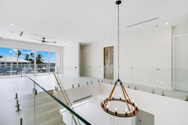 interior space featuring ceiling fan with notable chandelier