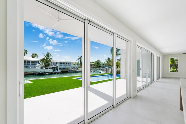 entryway featuring concrete flooring, ceiling fan, and a water view