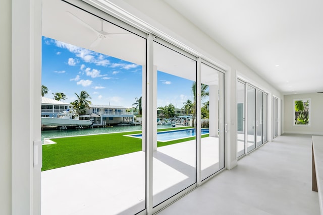 entryway featuring concrete flooring, ceiling fan, and a water view