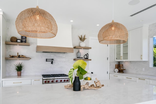 kitchen with white cabinetry, premium range hood, decorative light fixtures, and stainless steel gas cooktop