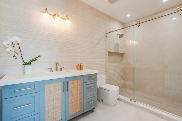 bathroom featuring vanity, toilet, a shower with shower door, and tile walls