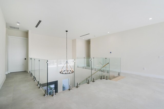 hall with an inviting chandelier