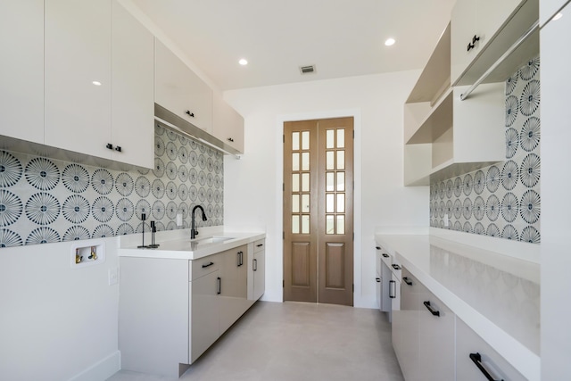 kitchen with white cabinetry, sink, and decorative backsplash