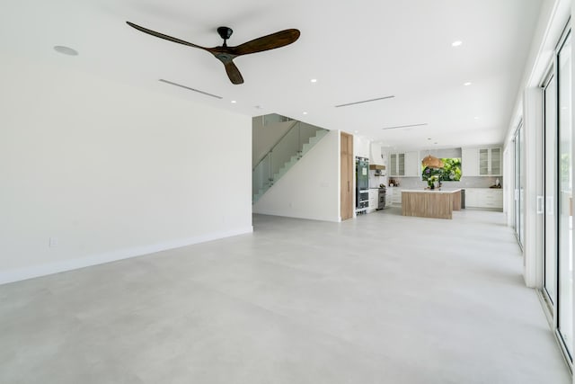 unfurnished living room with ceiling fan