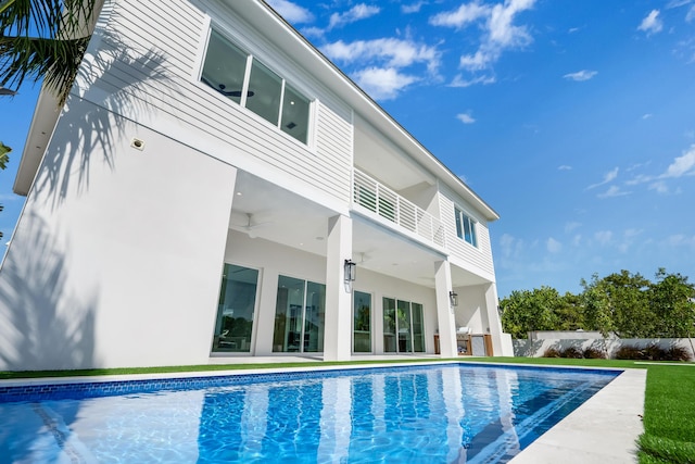 rear view of house featuring a fenced in pool and a patio area