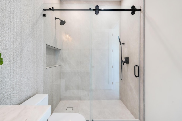 bathroom featuring vanity, an enclosed shower, and toilet