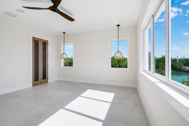 unfurnished room featuring a water view, ceiling fan, and a wealth of natural light