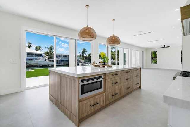 kitchen featuring pendant lighting, light brown cabinetry, and a kitchen island