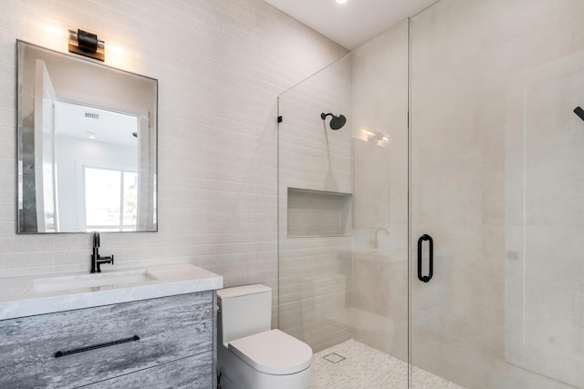 bathroom featuring vanity, tile walls, an enclosed shower, and toilet