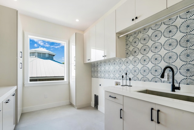 clothes washing area with cabinets, hookup for an electric dryer, hookup for a washing machine, and sink