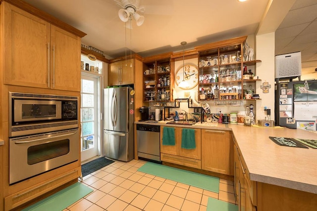 kitchen with light tile patterned floors, sink, hanging light fixtures, and appliances with stainless steel finishes