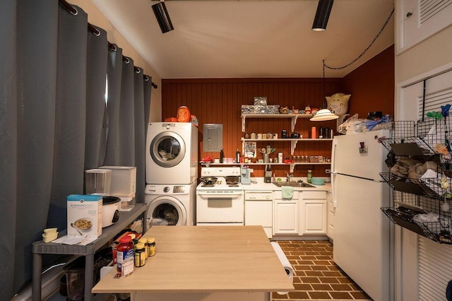 kitchen with stacked washing maching and dryer, sink, and white appliances