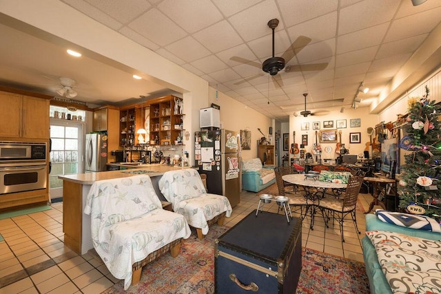 tiled living room featuring a paneled ceiling and ceiling fan