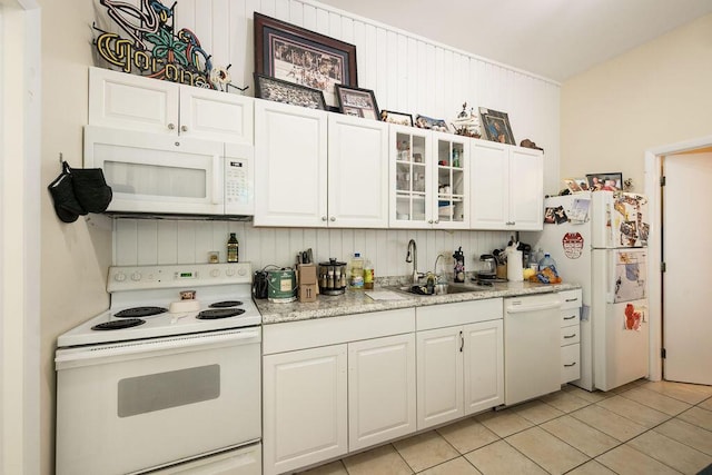 kitchen featuring white appliances, light tile patterned floors, sink, and white cabinets