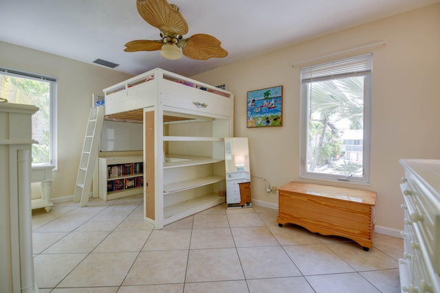 bedroom featuring a ceiling fan, baseboards, visible vents, and light tile patterned floors