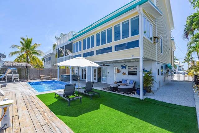 back of house featuring a fenced backyard, an outdoor hangout area, a hot tub, and ceiling fan