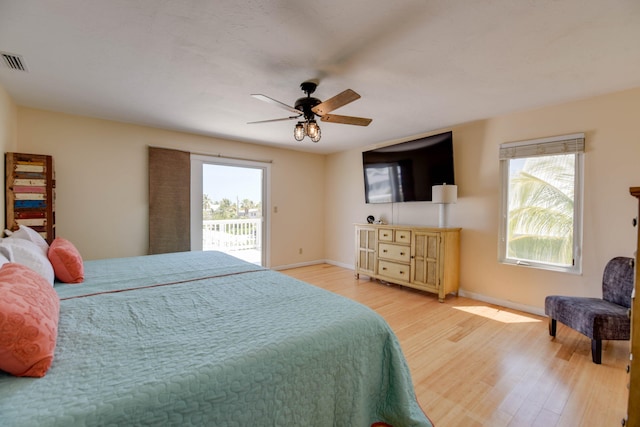 bedroom featuring access to outside, a ceiling fan, baseboards, wood finished floors, and visible vents