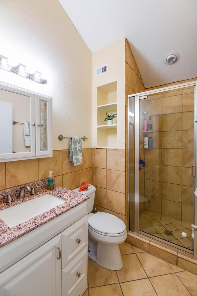 full bath with tile patterned flooring, tile walls, a shower stall, vaulted ceiling, and visible vents