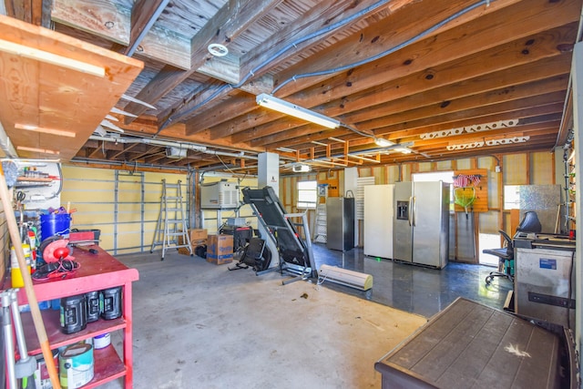 garage with freestanding refrigerator and stainless steel fridge