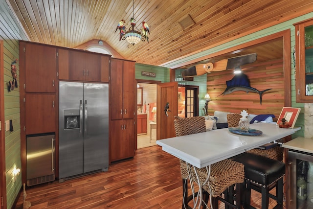 kitchen featuring dark hardwood / wood-style floors, stainless steel refrigerator with ice dispenser, wooden walls, and wood ceiling