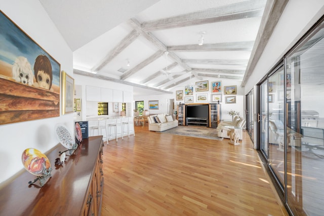 living room with light hardwood / wood-style floors and lofted ceiling with beams