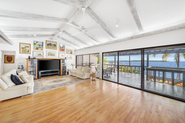 unfurnished living room with lofted ceiling with beams, ceiling fan, hardwood / wood-style floors, and a fireplace