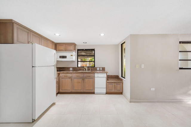 kitchen with light tile patterned flooring, sink, and white appliances