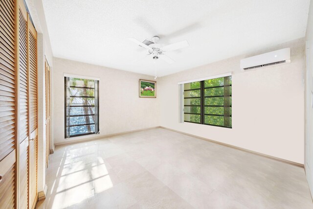 empty room featuring ceiling fan and a wall mounted AC