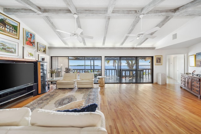 living room with hardwood / wood-style floors, beam ceiling, plenty of natural light, and ceiling fan