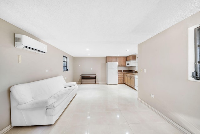 living room with a wall mounted air conditioner, light tile patterned floors, and a textured ceiling