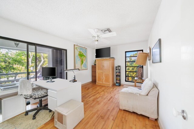 office area featuring ceiling fan, a textured ceiling, and light wood-type flooring