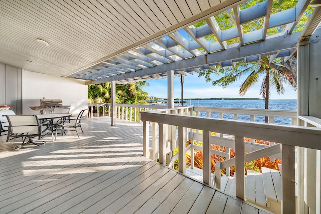 wooden terrace with a water view and a pergola