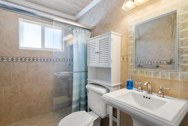 bathroom with sink, a shower with door, tile walls, ornamental molding, and toilet