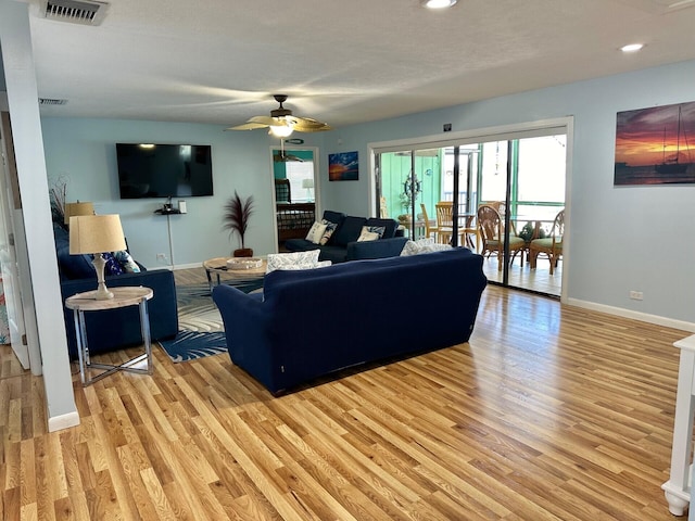 living room with ceiling fan and light wood-type flooring