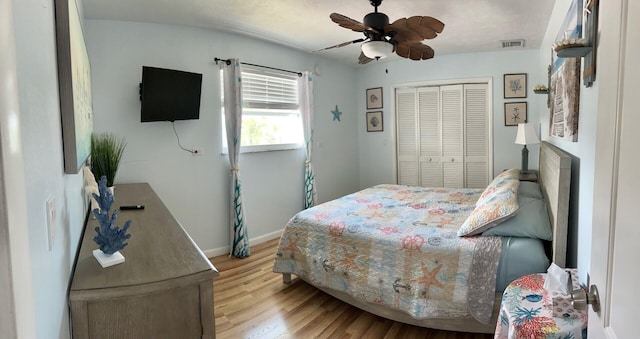 bedroom with ceiling fan, light hardwood / wood-style floors, and a closet