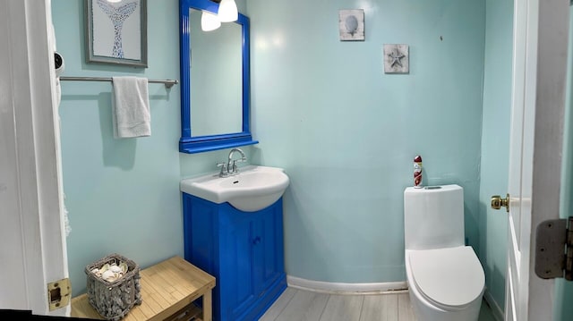 bathroom featuring vanity, wood-type flooring, and toilet