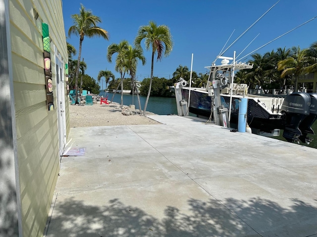 view of patio featuring a water view and a boat dock