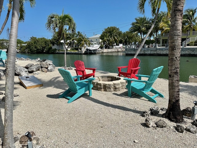 dock area with a patio, a water view, and a fire pit