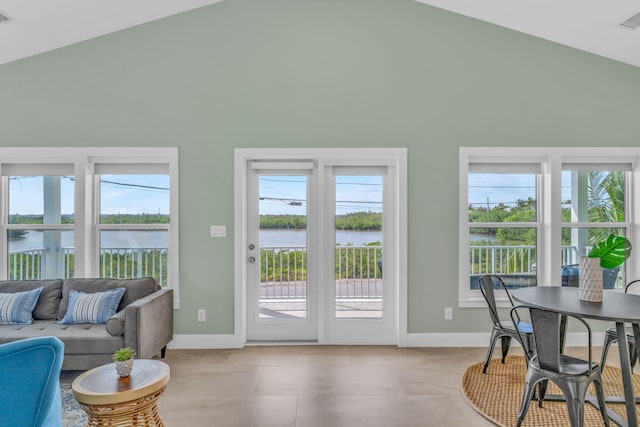 entryway featuring lofted ceiling, a water view, visible vents, and baseboards