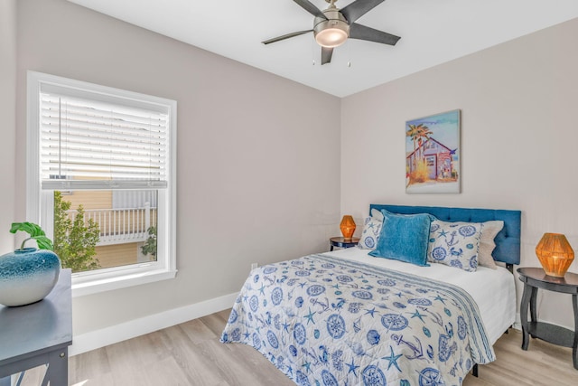 bedroom with ceiling fan, wood finished floors, and baseboards