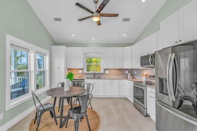 kitchen with stainless steel appliances, visible vents, a sink, and decorative backsplash