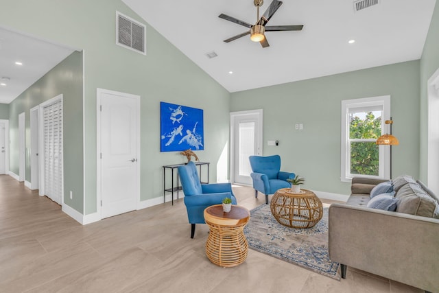 living area featuring high vaulted ceiling, visible vents, and baseboards