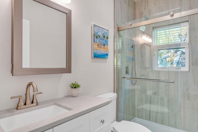 bathroom featuring a stall shower, vanity, and toilet