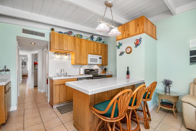 kitchen with sink, decorative light fixtures, electric range, kitchen peninsula, and decorative backsplash