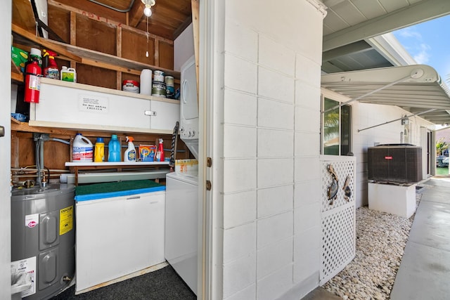 laundry room featuring stacked washer and dryer and water heater