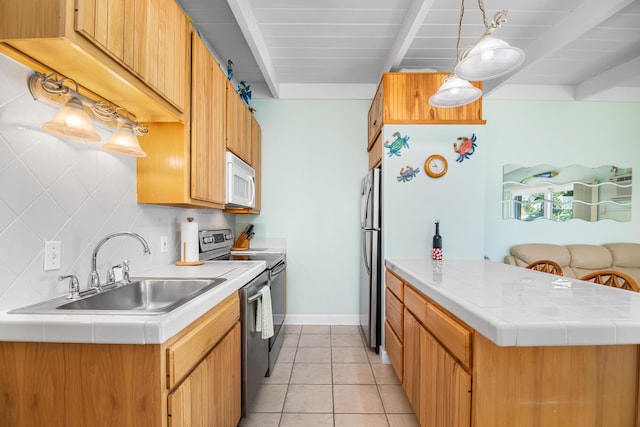 kitchen with sink, beamed ceiling, appliances with stainless steel finishes, kitchen peninsula, and pendant lighting