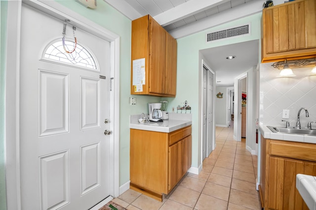 kitchen with lofted ceiling with beams, sink, backsplash, hanging light fixtures, and light tile patterned floors